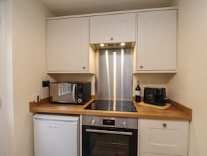 A compact kitchen with a built-in oven, a microwave, and a toaster. - 4 Lilac Cottages, Ainthorpe (Whitby)