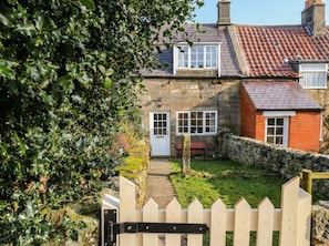 A traditional stone house with a red-tiled roof, a wooden gate, and a stone wall. - 4 Lilac Cottages, Ainthorpe (Whitby)