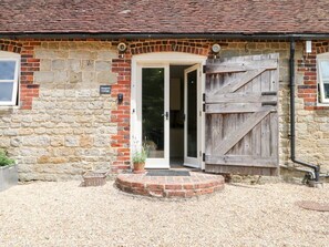 A stone building with a wooden door and a large wooden gate. - Hungers Cottage, Petworth. (Petworth)