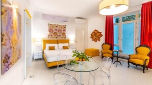 A room with a bed, a glass table, and two yellow armchairs. - Dimora Filangieri (Massa Lubrense)