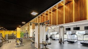 Uma academia com diversos equipamentos de exercício, incluindo esteiras e aparelhos de musculação.