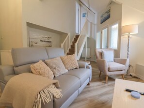 Ein Wohnzimmer mit einer Couch, einem Sessel und einer Lampe.