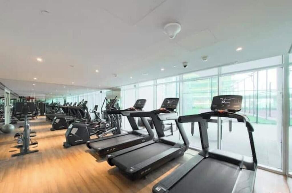 A gym with treadmills, exercise bikes, and weights.