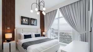 Une chambre d’hôtel moderne avec un grand lit, un bureau et une vue sur la ville.