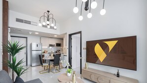 Une cuisine moderne avec un coin repas, un grand téléviseur à écran plat et un élément décoratif mural.
