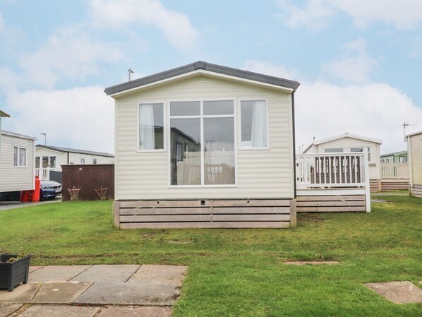 A single-story mobile home with a front porch, a large window, and a number '1019' on the side.
