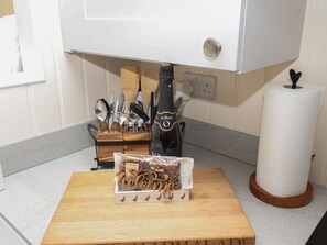 A kitchen counter with a wooden cutting board, a bottle of SORSO, a roll of paper towels, and a 'Welcome' sign. - Hillside Hut is near Ashbourne (Ashbourne)