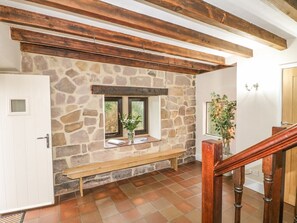 A stone wall with a bench, a wooden door, and a staircase with a wooden railing. - Woodlands Farm: Countryside Oasis (Ashbourne)