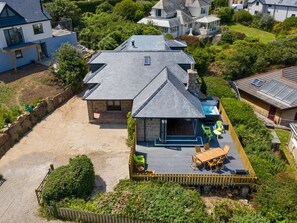Ein Haus mit einer großen Terrasse, einem Schwimmbecken und einer Steinterrasse.