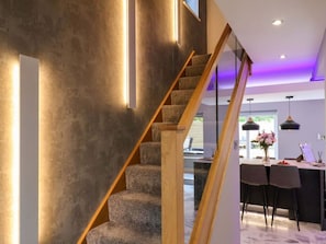 Ein modernes Interieur mit Treppe, Essbereich und Küche.