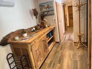 A wooden bar area with a rustic design, a painting on the wall, and a coat rack. - Apartment with AC, peaceful - 6 guests (Port-Vendres)