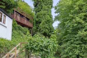 A white building with a wooden deck attached to the side. - Charming Flat 8 in Lynmouth (Lynmouth)