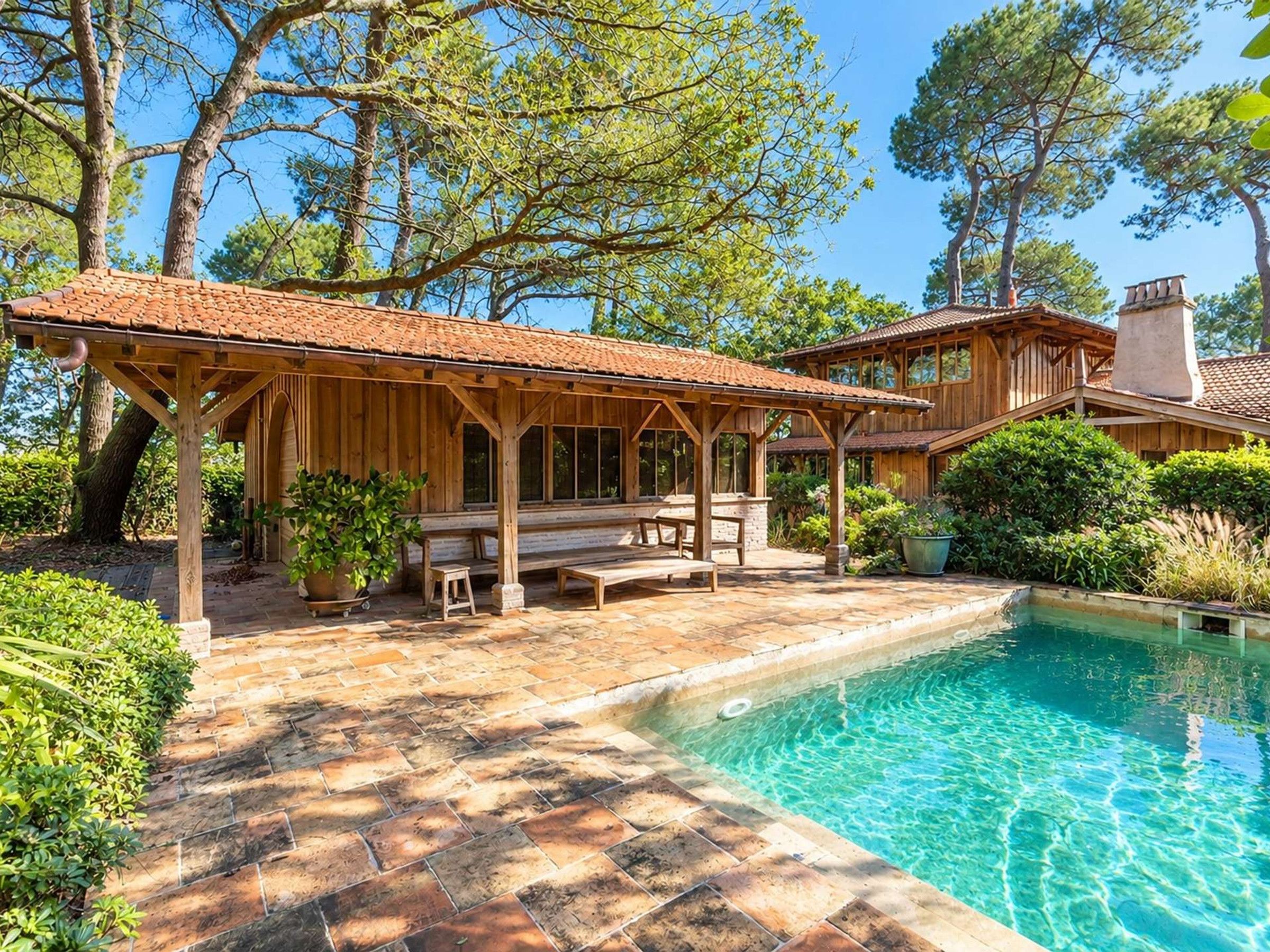 Ein Poolbereich mit Holzterrasse, einer integrierten Sitzbank und einer überdachten Lounge-Ecke.