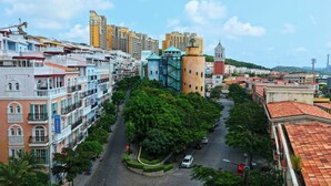 A cityscape with a prominent tower, a variety of multi-story buildings, and a street lined with trees. - Anna Seaview Hotel and Spa (Phu Quoc)