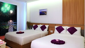 A hotel room with two beds, a night view of fireworks, and a framed picture on the wall. - Anna Seaview Hotel and Spa (Phu Quoc)