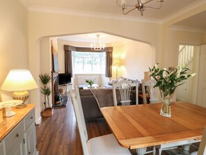 A dining area with a wooden table, chairs, and a vase of flowers. - 2 Gladstone Avenue, Melton Mowbray (Melton Mowbray)