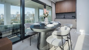 Un comedor moderno con una mesa redonda, seis sillas y un jarrón de flores.