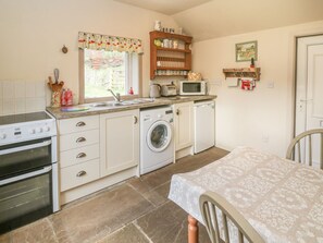 Eine kleine Küche mit Waschmaschine, Mikrowelle und Backofen.