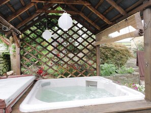 A hot tub under a wooden pergola with a lattice backdrop and hanging lanterns. - Swang Cottage, Glaisdale (Whitby)