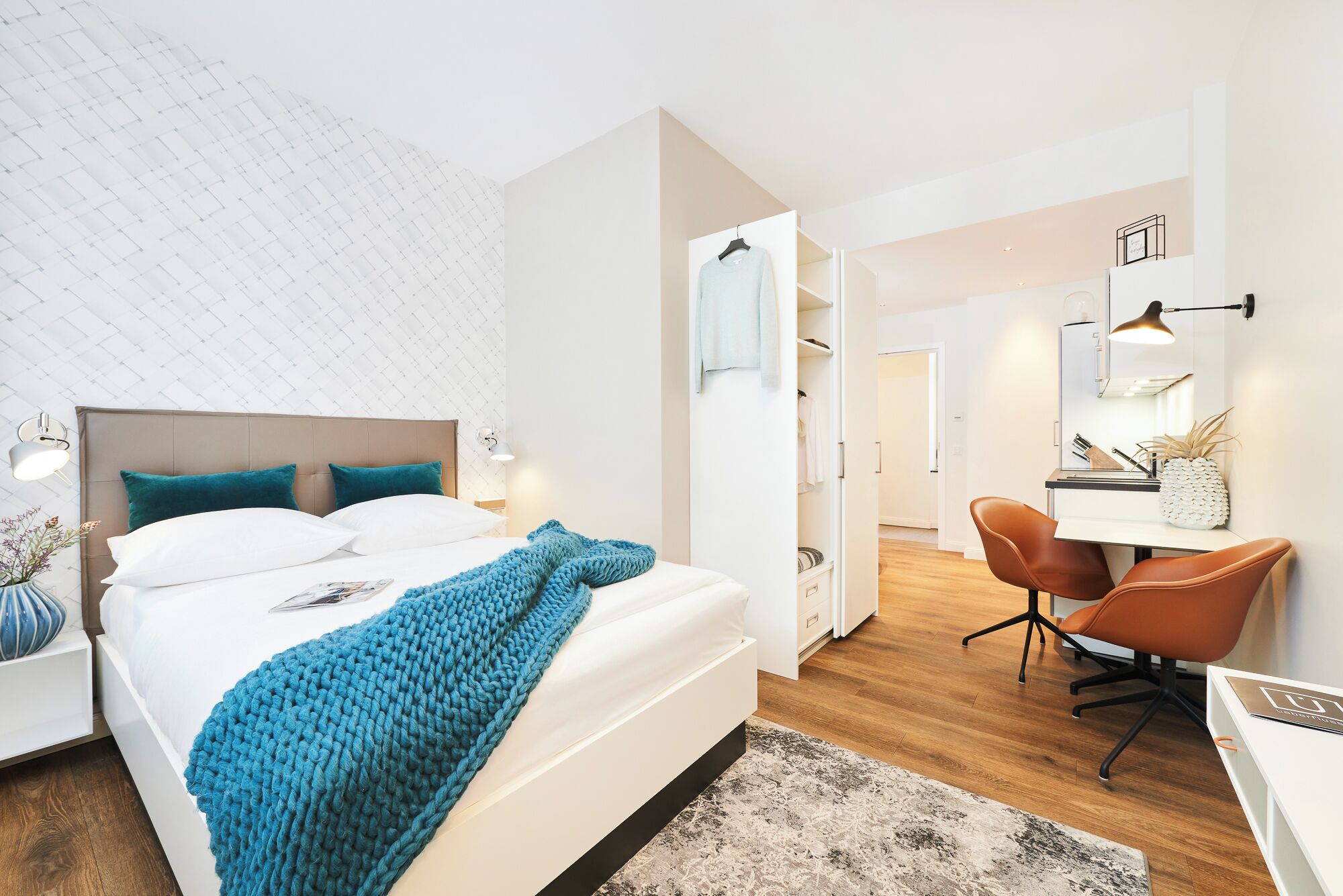 Una habitación de hotel moderna con cama, escritorio y silla.