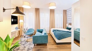 Een moderne hotelkamer met een bed, een bank, een stoel, een bureau en een televisie.