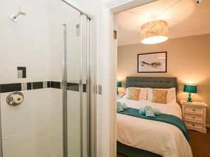 A hotel room with a glass shower enclosure, a bed with a green bedspread, and a framed artwork on the wall. - Kempton, Bowness-On-Windermere (Windermere)