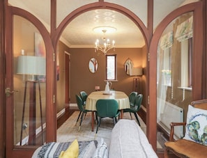 A dining area with a round table, chairs, and a chandelier. - Kempton, Bowness-On-Windermere (Windermere)