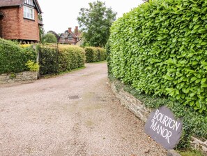 Ein Schotterweg führt zu einem Anwesen namens 'Bourton Manor'.