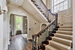 A grand staircase with ornate balusters and carpeted steps, leading to an upper floor. - Batheaston House, Batheaston (BATH)