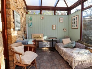 A cozy room with a stone wall, a wooden chair, a small table, a sofa, and a bed. - Vive House, Ribchester (Preston)