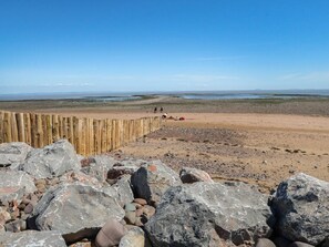 A beach with a wooden fence, large rocks, and a clear sky. - Hedgehog Cottage, Wheddon Cross (Minehead)