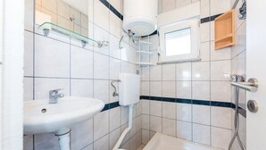 Un baño con lavamanos, inodoro, bañera y ducha.