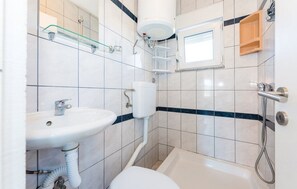 Ein Badezimmer mit Waschbecken, Toilette, Badewanne und Dusche.
