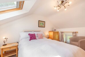 A bedroom with a bed, bedside table, nightstand, dresser, and a ceiling light fixture. - Cwmdu Cottage, Newcastle Emlyn (Newcastle Emlyn)