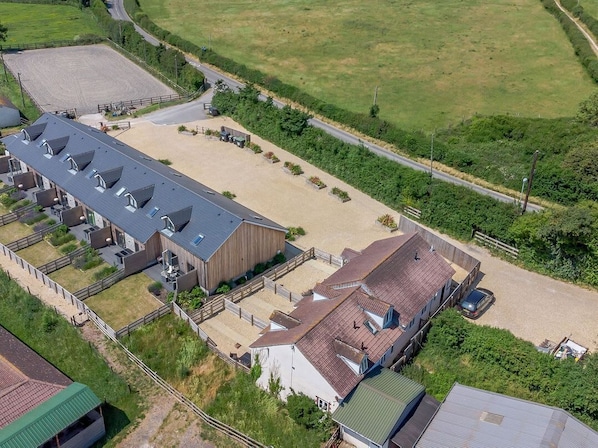 Un centre équestre doté de plusieurs écuries, d’une grande carrière d’entraînement en plein air et d’un parking clôturé.