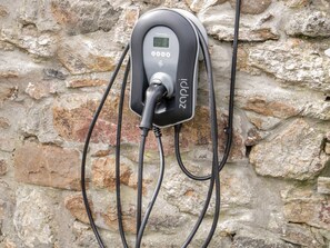 Eine Ladestation für Elektrofahrzeuge an einer Steinmauer befestigt.
