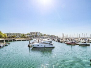 A marina with boats docked, a clear sky, and buildings in the background. - Flat 3 Channel View, Torquay (Torquay)