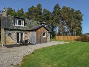A stone house with a wooden extension, a gravel driveway, and a well-maintained lawn. - Discover Feagour in Scenic Laggan (Newtonmore)