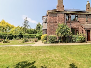 A two-story brick house with a well-maintained lawn and garden. - Bentfield House, Whiston (Rotherham)