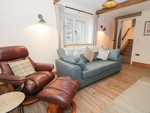 A living room with a leather armchair, a blue sofa, and a wooden floor. - Y Stabl, Cerrigydrudion (Corwen)