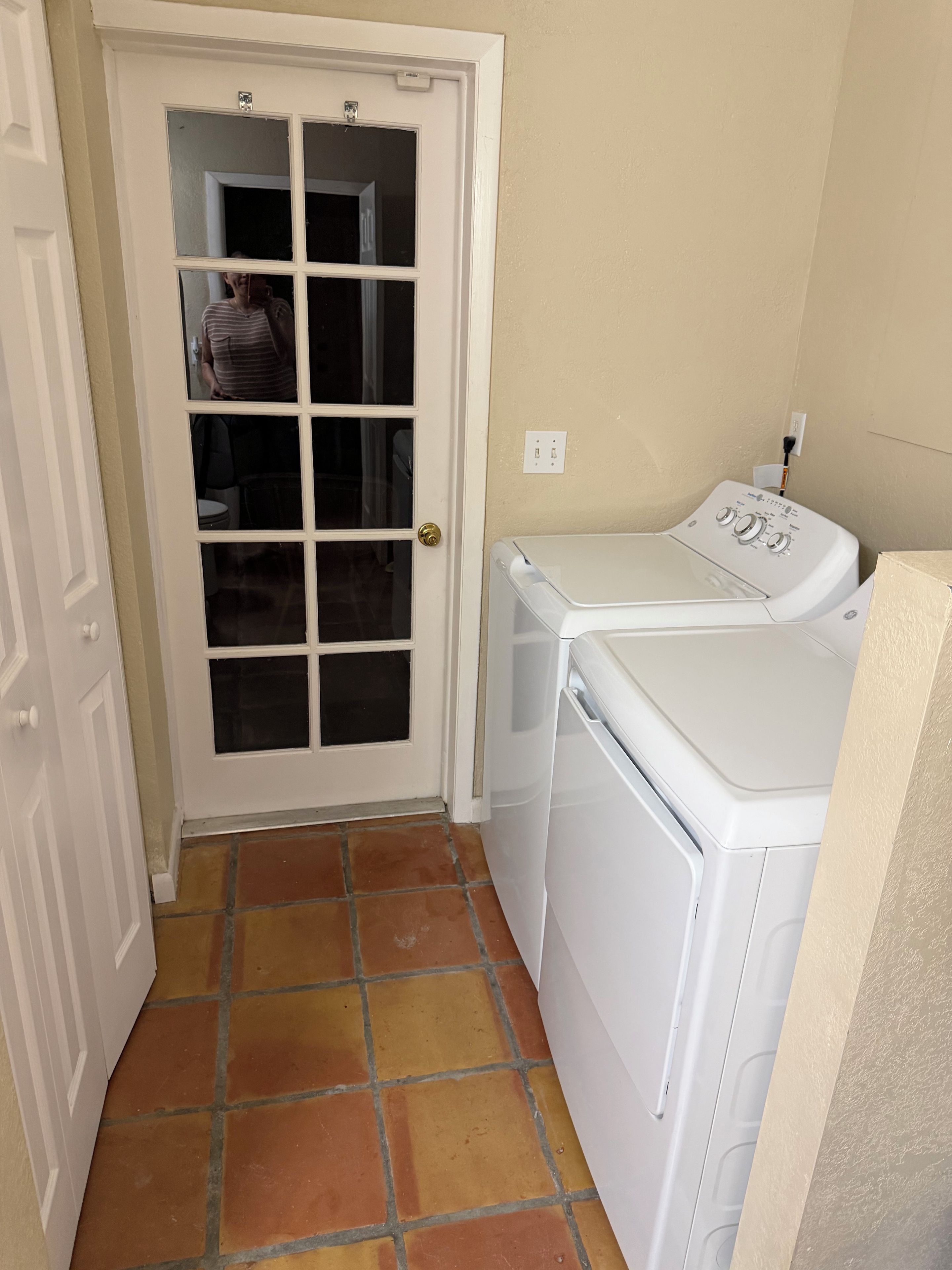 A laundry room with a door, a washing machine, and a dryer.