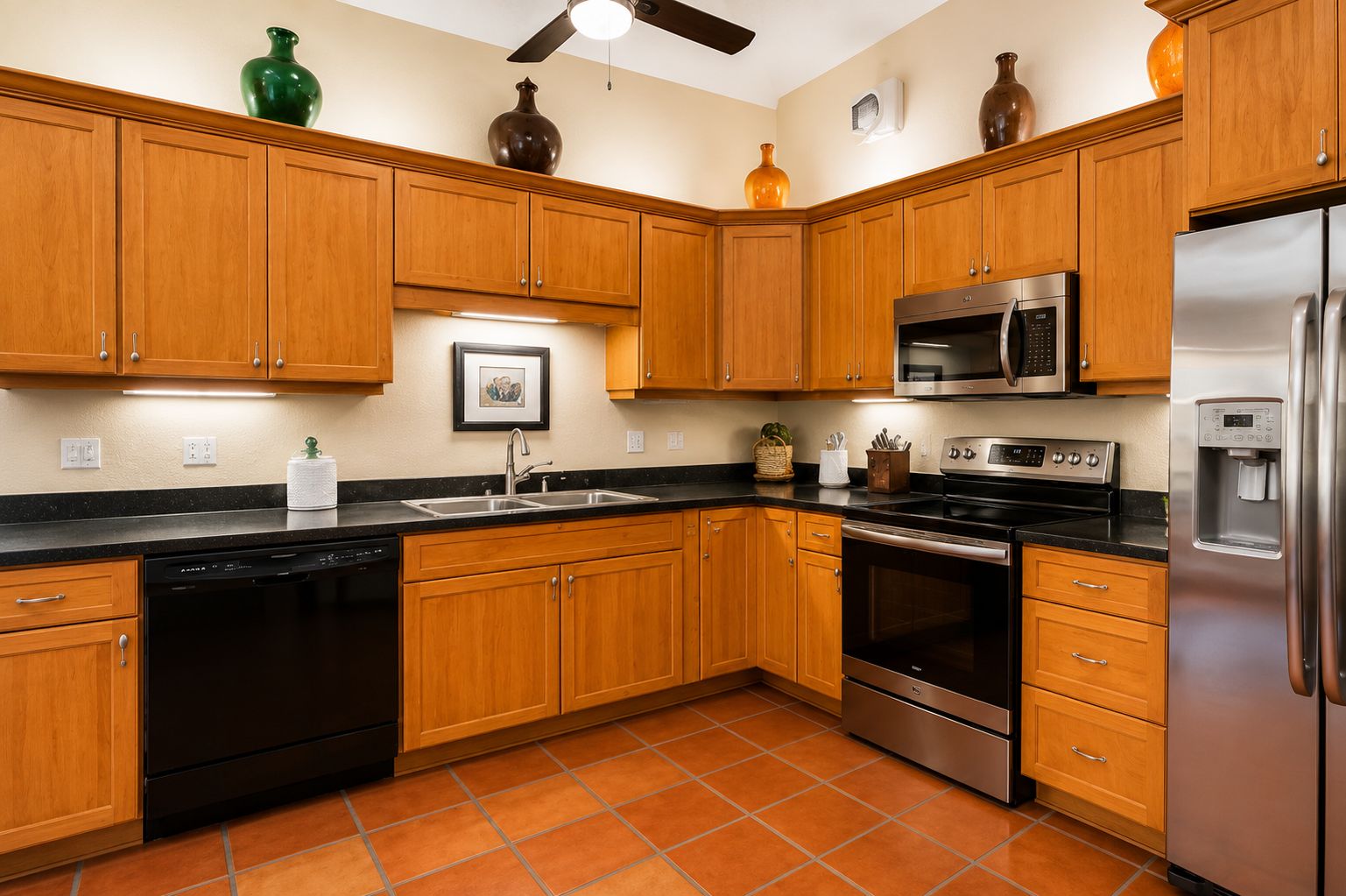 A kitchen with wooden cabinets, a dishwasher, a microwave, an oven, and a refrigerator.
