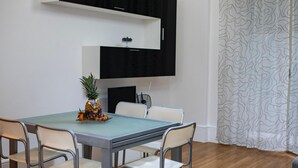 Un comedor con una mesa, sillas, una piña y un frutero.