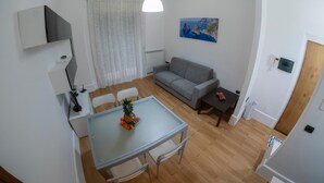 Una sala de estar moderna con una mesa de comedor, sofá y un cuadro en la pared.
