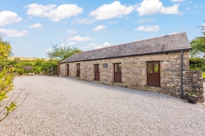 A stone building with a gravel driveway and a sign that reads 'The Studio.'