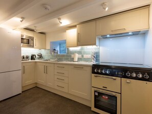 A kitchen with a microwave, stove, oven, and cabinets. - Rose Cottage, St Ives (St. Ives)