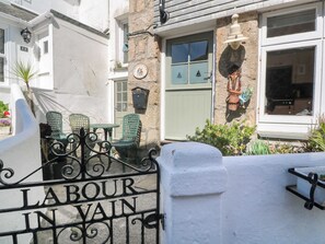 A white building with a sign reading 'LABOUR IN VAIN' and a green door. - Labour in Vain, St Ives (St. Ives)