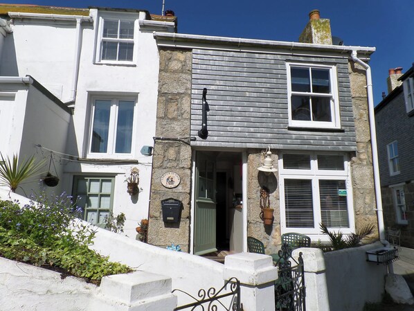 A two-story building with a stone facade, a visible entrance, and a small outdoor seating area. - Labour in Vain, St Ives (St. Ives)