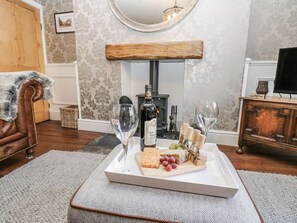A room with a fireplace, a wooden bench, a white tray with cheese and grapes, and wine glasses. - 26 Frenchgate, Richmond (Gateway)