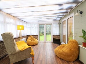 Ein Zimmer mit einer Couch, einem Sitzsack, einer Lampe und einem Kamin.